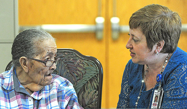 Patricia Cultrara, director of the Adult Day Health Care Program at Sisters of Charity Hospital, speaks to 87-year-old Essie Cooper about the program. (Dan Cappellazzo/Staff Photographer)