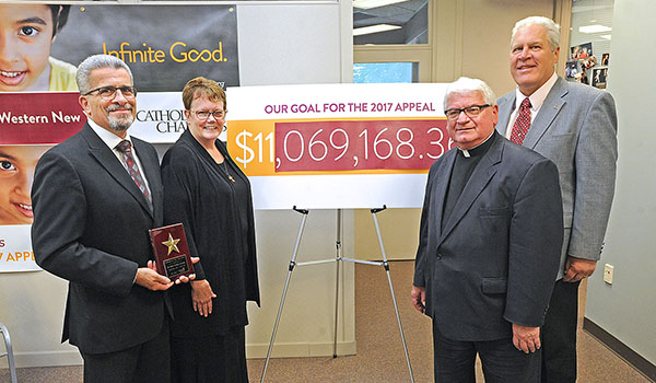 Framed by a goal reached, Msgr. David S. Slubecky and Sister Mary McCarrick, OSF, diocesan director of Catholic Charities of Buffalo stand with St. Peter Parish, of Lewiston Parish Appeal Chairs Joe Conti, left and Bill Taczak, during a press conference at Catholic Charities headquarters announcing the goal of $11 million was reached. The Lewiston parish exceeded it's goal by 25%, the highest percentage among all parishes contributing more than $100,000.   
    Dan Cappellazzo/Staff photographer
