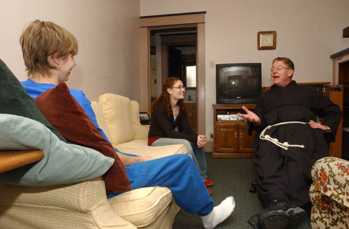 In 2006, `Dave` a resident at the Franciscan Center talks with Nicole Carroll, emergency shelter house coordinator, and Father Joseph Bayne, OFM, Conv. The Franciscan Center is a dual runaway homeless youth shelter that was started in 1980.