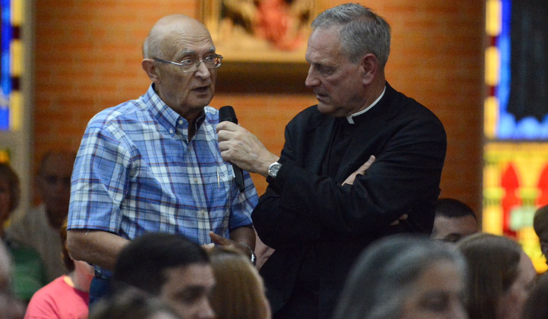 Rimas Slavickas (left) asks a question to the panelists at St. Leo the Great Parish, where Msgr. Robert Zapfel (right) served as moderator of a discussion titled 'Let's Talk About...The Future of the Catholic Church.` (Patrick McPartland/Managing Editor)