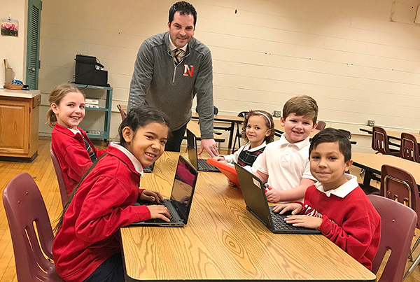 Principal Christopher Gardon visits with Nativity of Our Lord School students as they learn how to use Chrome books and iPads in  technology class. (Courtesy of Nativity of Our Lord School)