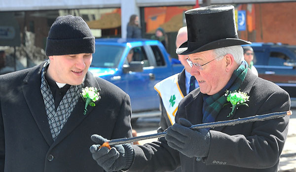 Bishop Richard J. Malone shows his Blackthorn cane to his secretary, Father Ryszard Biernat as the pair marches the St. Patrick's Day Parade along Delaware Avenue in the City of Buffalo.