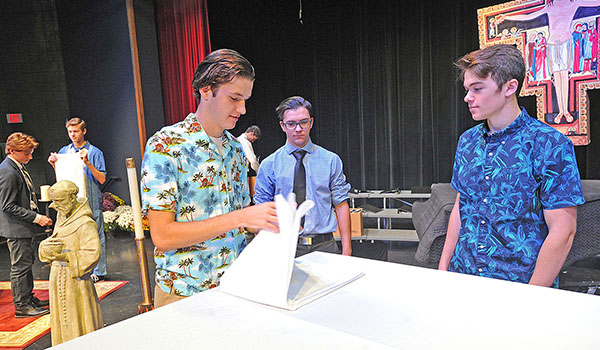 Erik Pawelski (from left), Noah Unger and Tyler Piwowarski, disassemble the altar after a Mass in the school auditorium. As members of the Alverna homeroom, they take care of the faith-based events at the school. (Dan Cappellazzo/Staff Photographer)