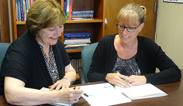 Mary Holzerland, (left) principal of Cardinal O'Hara High School, goes over school and project details with Jill Monaco, newly named assistant principal.