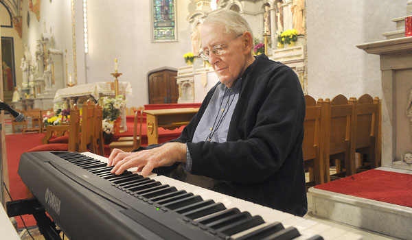 Bob Chambers, longtime organist for Holy Angels Parish in Buffalo, gives a demonstration of what he has been doing at the parish for the past 70 years. The parish will honor him with a dedication on May 13, with a special Mass and reception. (Dan Cappellazzo/Staff Photographer)