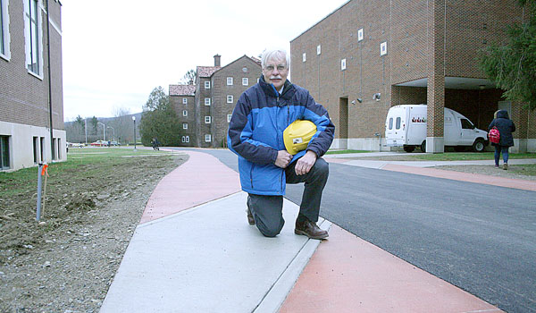 Phil Winger, St. Bonaventure University's associate vice president for facilities, is pictured on a sidewalk in which the design elements pay tribute to the railroad that was in use on campus in the 1930s. (Courtesy of Tom Donahue)