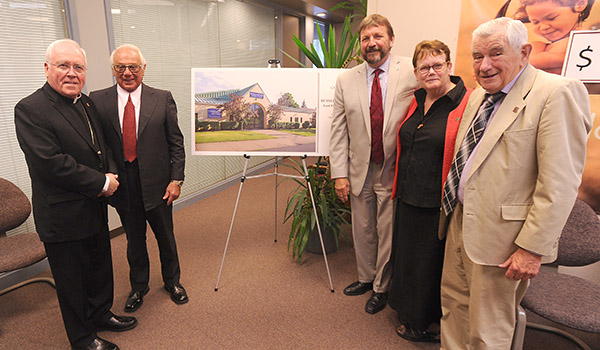 Bishop Richard J. Malone stands with Russell J. Salvatore, Catholic Charities chief executive officer Dennis C. Walczyk, chief executive officer, Sister Mary McCarrick, OSF, diocesan director, Catholic Charities, and Robert M. Bennett, Catholic Charities 2018 Appeal chair, in front of a rendering of the renamed Russell J. Salvatore Food Pantry and Outreach. (Dan Cappellazzo/Staff Photographer)
