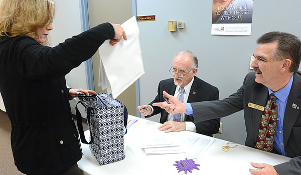 Catholic Charities Appeal representatives Frank Andzik (center), donor and event coordinator,and Fred Heuer (right), appeal parish coordinator, collect the donations from this weekend's Mass's to the Catholic Charities Appeal as appeal parish chairs & pastors drop them off at Catholic Charities Montante Administrative Center.
(Patrick McPartland/Staff Photographer)