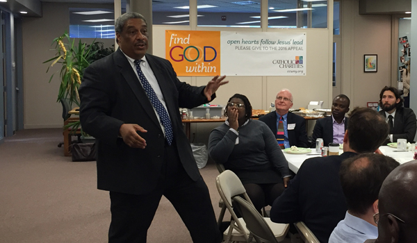 Ralph McCloud (standing) addresses the Catholic Charities of Buffalo team Friday afternoon. (Photo by George Richert)