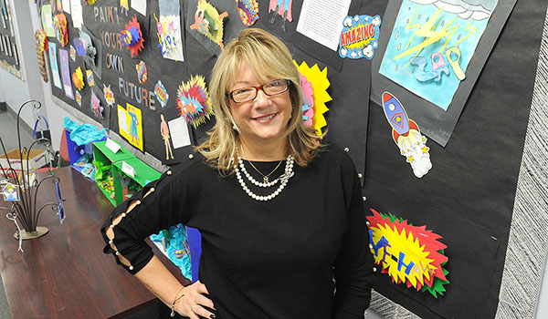 Art teacher Mary McIntyre, of SS. Peter & Paul School in Williamsville, stands in front of some of her students' work. (Dan Cappellazzo/Staff Photographer)