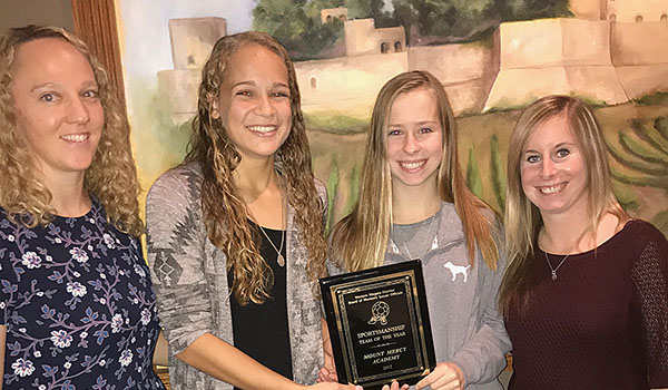 Assistant Coach Mary Colby (from left), co-captain Alesia Hamm, co-captain Abigail Hillery and Coach Brittany Myers hold their team's sportsmanship award. (Courtesy of Mount Mercy Academy)