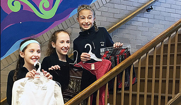 Christ the King Catholic School sixth-graders Carly Illos and Catherine Fillip and eighth-grader Sarah Fillip deliver collected items to Our Lady of Black Rock School in Buffalo.