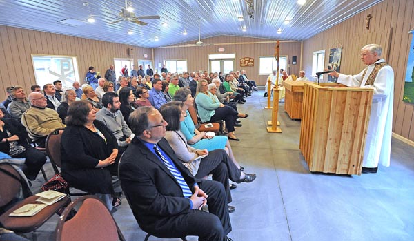 Msgr. Fran Weldgen delivers the homily at the new center where worship can be held on Camp Turner in Allegany State Park. The Mass was held to open the new center. Dan Cappellazzo/Staff Photographer)