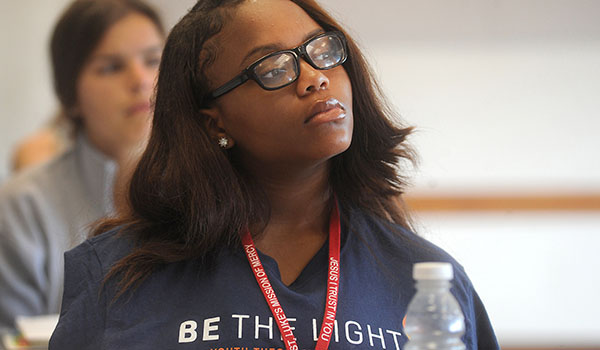 Hutch Tech sophomore Tyteiona Huggins listens to Denise Phillips Beehag, director of Refugee and Employment Services at the International Institute of Buffalo, at the `Be The Light Theology Institute during a week-long experience of faith, justice and service for high school rising juniors and seniors, in residence at Canisius College. (Dan Cappellazzo/Staff Photographer)
