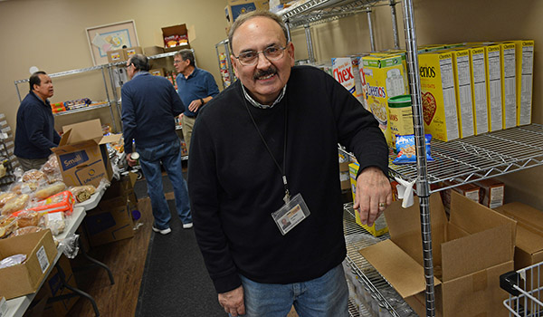Community Outreach assistant Joe Rizzo stands in the food pantry area where those in need can access non-perishable and fresh baked food at the Catholic Charities Hearts and Hands food pantry, 2710 North Forest Road, Getzville. (Dan Cappellazzo/Staff Photographer)