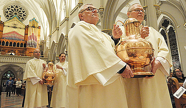 Urns containing the sacred oils are brought forth to the altar at St. Joseph Cathedral during the Chrism Mass. (Patrick McPartland/Staff Photographer)