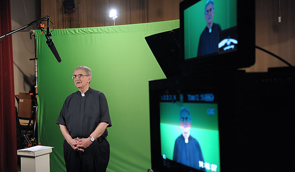 Father Richard `Duke` Zajac gets ready to record some public service announcements with Daybreak TV as he tours the Office of Communications of the Diocese of Buffalo.  (Patrick McPartland/Staff Photographer)