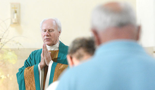 Father Robert Mock, pastor, leads members of Cursillo in prayer as the group celebrates a reunion Mass with prayer and song at St. Benedict Church in Eggertsville. (Patrick McPartland/Staff Photographer)