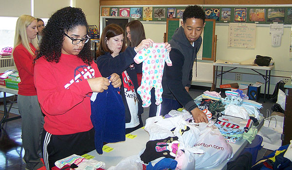 Students from Niagara Falls Jr./Sr. High School sort baby clothes at the St. Gianna Molla Pregnancy Outreach Center - Niagara County. All students from the school went out into the community for their annual Day of caring. (Patrick J. Buechi/Staff)