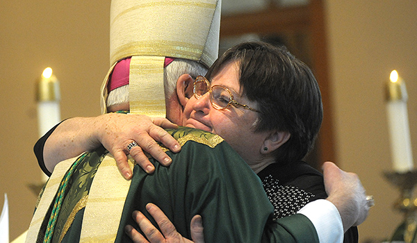 An emotional Deborah Brown hugs Bishop Richard J. Malone during a Mass where Brown was appointed as Pastoral Administrator of Saint John the Baptist Parish, Alden. Brown is the first non-religious woman to run a parish in the diocese. (Dan Cappellazzo/Staff Photographer)