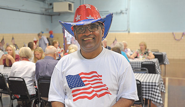 Father George Devanapalle, administrator at SS. Joachim & Anne Church, Attica, is all smiles during luncheon at St. Vincent Auditorium celebrating his U.S. citizenship. (Dan Cappellazzo/Staff Photographer)