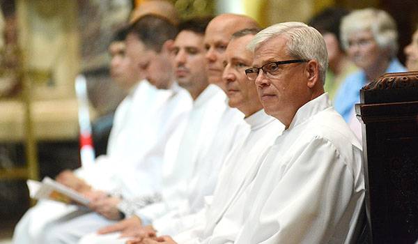 Seven of the 15 men being ordained to the order of deacon sit before the congregation at Our Lady of Victory Basilica. (Dan Cappellazzo/Staff Photographer)