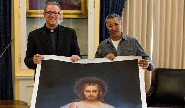 Bishop Robert Barron (left) of Los Angeles and Daniel diSilva hold a display of the Divine Mercy image. (Courtesy of Kristen VonBerg)
