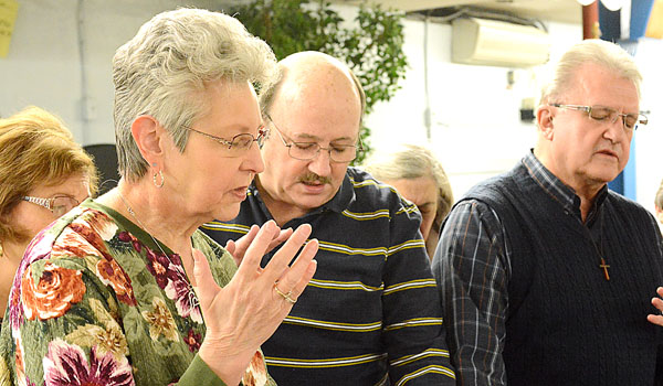 Diane Dryja (left) and others from the prayer meeting at St. Lawrence Parish offer prayers for a fellow member. (Patrick McPartland/Staff Photographer) 