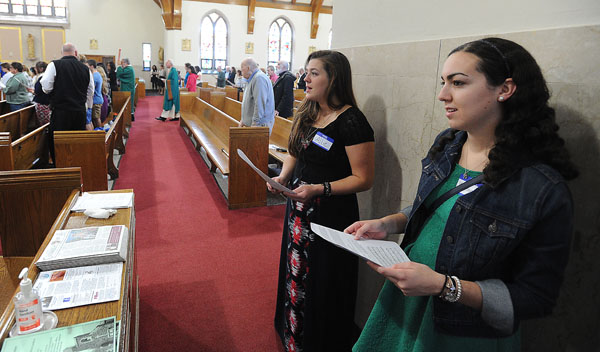 Dynamis WNY members Allie Herian and Katherine Panzica pass out Mass flyers at St. Benedict Parish on Sunday, Oct. 16. Dynamis members plan to offer hospitality at Masses throughout the diocese. (Dan Cappellazzo/Staff Photographer)