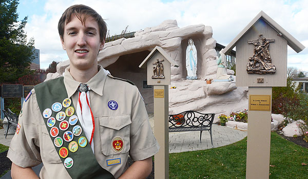 Joseph McEachon stands by the Stations of the Cross he designed, funded, built and installed at St. Gregory the Parish as part of his Eagle Scout project. (Patrick McPartland/Staff Photographer)