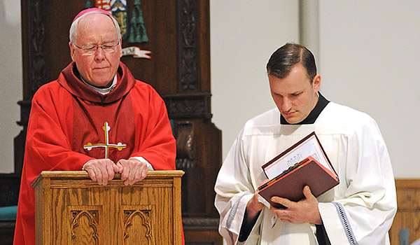 Bishop Richard Malone and Father Ryszard Biernat pray during the Solemn Celebration of the Lord's Passion, Good Friday Liturgy at St. Joseph Cathedral. (Dan Cappellazzo/Staff Photographer)