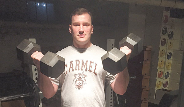 Father Ryszard Biernat lifts weights as part of his physical regimen.