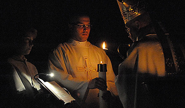 Deacon Michael LaMarca assists Bishop Richard J. Malone with the lighting of the Paschal Candle at the Easter Vigil at St. Joseph Cathedral, Buffalo, on Saturday night. (Patrick McPartland/Staff Photographer)