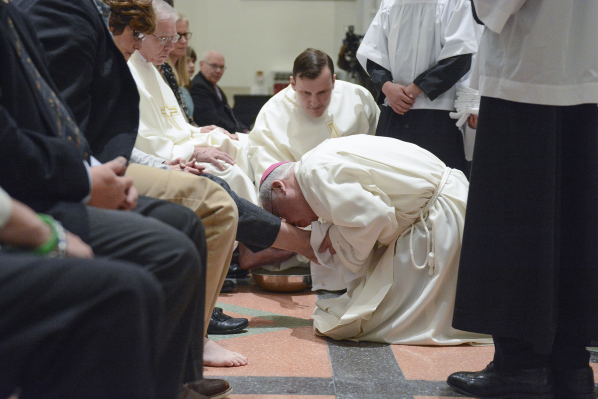 Bishop Richard J. Malone washes the feet of twelve at Evening Mass of the Lord's Supper at St. Joseph Cathedral. (Patrick McPartland)