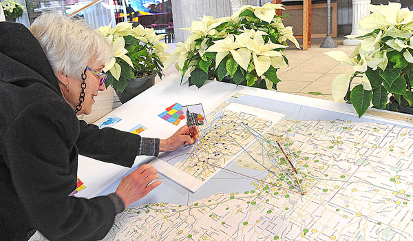 Mary Jo Ketchum, from the Church of the Annunciation in Elma, places a marker with a photo of St. Joseph Cathedral in Buffalo during a Mass where the church unveiled its diocesan map diorama. This is a growing project that involves parishioners tying strings from their childhood parish to Annunciation to show their faith trail. (Dan Cappellazzo/Staff Photographer)