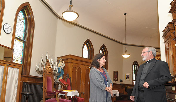 Carol Anne Cornelius, energy manager for the Diocese of Buffalo, and Msgr. Salvatore Manganello, pastor, are excited about the money saved with the installation of energy efficient light bulbs at St. Louis Church. (Patrick McPartland/Managing Editor)