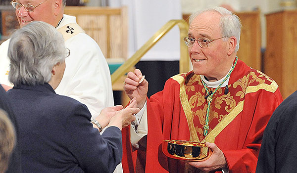 Bishop Richard J. Malone is calling for priests to distribute the consecrated hosts with special care, along with several other recommendations to combat flu season. (WNYC File Photo)