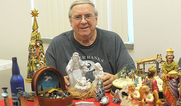 Father Roy Herberger holds one of the hundreds of Nativity scenes he has collected over the years. (Dan Cappellazzo/Staff Photographer)