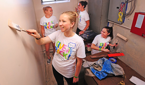 Give Back volunteers Mary Russell, Sarah Mullin, Regina Pollack and Alyssa Cometto paint a small office at the St. Lawrence Church Food Pantry on East Delavan Avenue. Dozens of Catholic youth volunteers painted, cleaned and organized area non for profit organizations at four separate locations throughout the city. (Dan Cappellazzo/Staff Photographer)