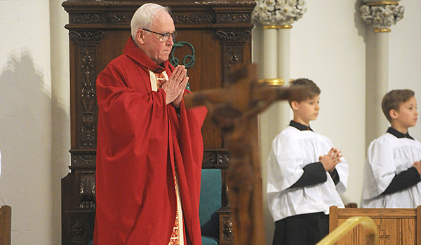 As a wooden cross of Jesus Christ stands before the altar, Bishop Richard J. Malone celebrates a solemn liturgy on Good Friday. (Dan Cappellazzo/Staff Photographer)