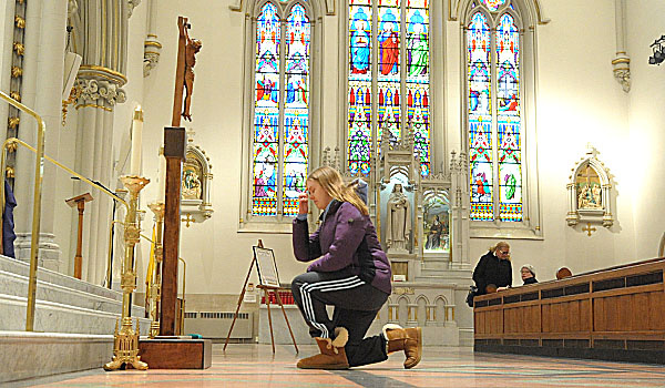Members of the congregation approach and venerate the cross at the conclusion of the Good Friday celebration at St. Joseph Cathedral. (Patrick McPartland/Staff Photographer)