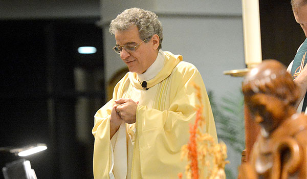 Father David Bellittiere, spiritual director for the Friends of St. Peregrine, stands behind a statue of St. Peregrine at St. Stephen Church in Grand Island during the Sacrament of the Anointing of the Sick. (Patrick McPartland/Managing Editor)