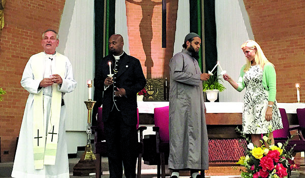 Msgr. Robert E. Zapfel (left) hosts an Interfaith Prayer Service for Peace at St. Leo the Great Church with local faith leaders just days after a Catholic priest was brutally martyred on the altar while saying Mass in France. Joining Msgr. Zafpel (from left) are Rev. Craig Pridgen, True Bethel Baptist Church, Niagara Falls; Imam Syed Khalil, Islamic Society of Niagara Frontier; and Cantor Penny Myers, Temple Beth Zion, Amherst. (Courtesy of St. Leo Church)