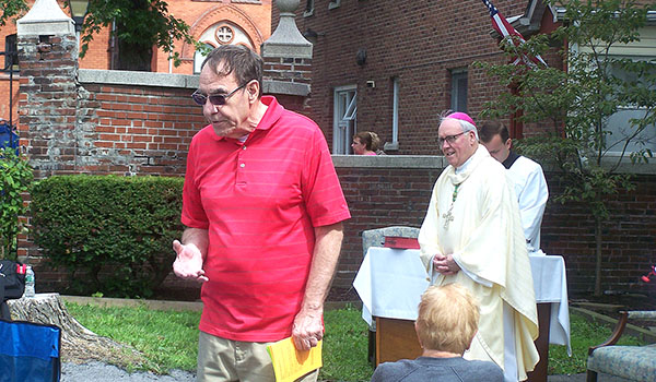 Little Portion Friary volunteer Joe Muhitch speaks to other volunteers before an outdoor Mass to celebrate the emergency shelter's 35th anniversary. Bishop Richard J. Malone and Father Ryszard Biernat celebrated the Mass, which took place Aug. 5 outside the downtown Buffalo friary. (Patrick J. Buechi/Staff)