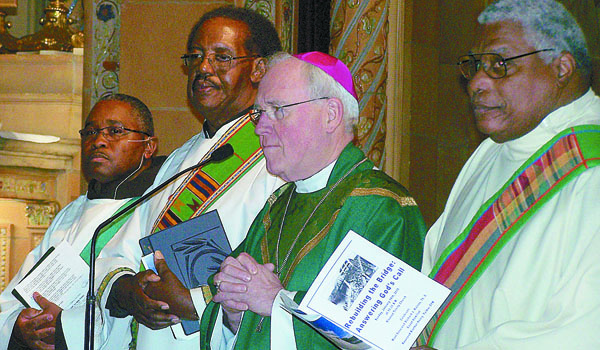 Bishop Richard J. Malone joins Reverend Brother Henry Fulmer, OSF; Deacon Jimmie Boyd and Deacon Ronald Walker in singing the gathering hymn, `All Are Welcome` during the Jan. 18 Martin Luther King Mass held at Blessed Trinity Parish in Buffalo. 