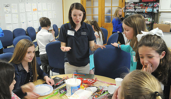 Mount St. Mary's sophomore Marissa Brandel helps area Catholic School eight graders design and market `the most delicious dessert` on Friday March 24, during the annual Mount St. Mary Academy Entrepreneur and Leadership workshop for middle school students. (Dan Cappellazzo/Staff Photographer)