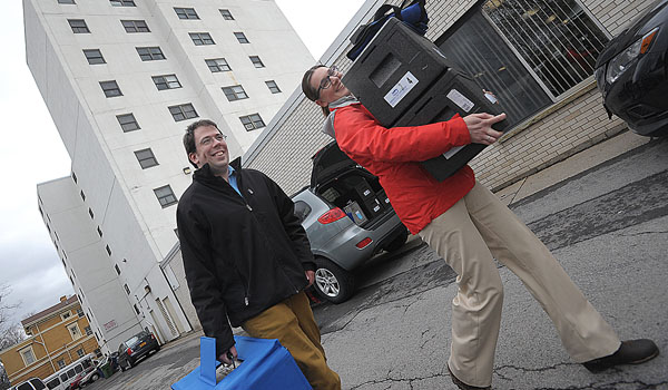 Diocese of Buffalo employees Mike Slish and Sarah Leahy pick up their Meals on Wheels meals at the Summer Street Senior Center. (Dan Cappellazzo/Staff Photographer)
