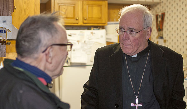 Bishop Richard J. Malone spends time with one of the clients of the Meals on Wheels organization.