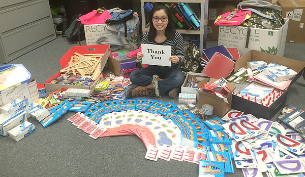 Ting Gao, founder of Third Non-Profit, sits among the school supplies she has bought for needy students. The Mount St. Mary Academy senior started the charity after seeing a need in her community. (Courtesy of Mount St. Mary Academy)
