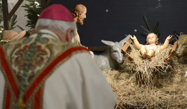 Bishop Richard J. Malone places the Baby Jesus in the manger during the procession at Midnight Mass at St. Joseph Cathedral (Patrick McPartland)